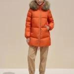 Modelo con abrigo acolchado naranja Alaska de Dichi con cuello de pelo